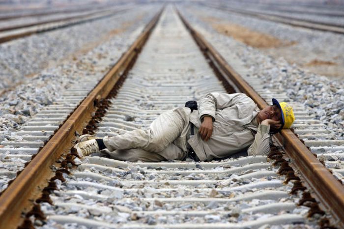 A worker naps on the railway at the construction site of Wuhan North Railway Marshalling Station in Wuhan